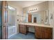 Retro bathroom featuring a blue carpet, wooden vanity and sink with a large mirror and floral wallpaper at 2912 Doncaster Dr, Charleston, SC 29414