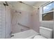 Bathroom featuring a white tub and toilet, light pink tile and window at 2912 Doncaster Dr, Charleston, SC 29414