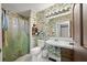 Tropical-themed bathroom with patterned wallpaper, white toilet, shower with curtain and vanity at 2912 Doncaster Dr, Charleston, SC 29414