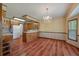 Traditional eat-in kitchen with wood cabinets, laminate counters, and wood-look floors under chandelier lighting at 2912 Doncaster Dr, Charleston, SC 29414