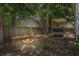 Wonderful backyard featuring a wooden fence, a built-in fire pit with a fire burning, and a seating area at 2916 Shadow Ln, North Charleston, SC 29406