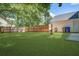 Lush backyard featuring manicured grass, a wooden fence, and mature trees at 2916 Shadow Ln, North Charleston, SC 29406