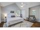 Light-filled bedroom with ceiling fan, hardwood floors, a sitting chair, and two bedside tables at 2916 Shadow Ln, North Charleston, SC 29406
