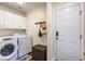 Bright laundry room with a washer and dryer, white cabinets, and convenient storage options near the door at 2916 Shadow Ln, North Charleston, SC 29406