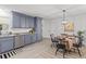 Modern kitchen featuring blue cabinets, granite countertops, stainless steel appliances, and a dining area at 300 Oklahoma Pl, Ladson, SC 29456