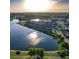Scenic aerial view of a colorful home community surrounding a serene lake at sunset at 3046 Sweetleaf Ln, Johns Island, SC 29455