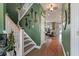 Hallway with hardwood floors, decorative keys, and a view into the cozy living room, enhancing the home's charm at 3046 Sweetleaf Ln, Johns Island, SC 29455