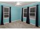 Bedroom featuring two windows with curtains, teal walls, neutral carpet, and a ceiling fan at 309 Padgett Loop, Walterboro, SC 29488