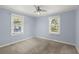 Bedroom featuring two windows, light blue walls, neutral carpet, and a ceiling fan at 309 Padgett Loop, Walterboro, SC 29488