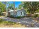 A light blue home with a brick chimney is surrounded by mature trees and has a concrete driveway at 309 Padgett Loop, Walterboro, SC 29488