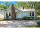 Charming light blue one-story home with brick chimney and well-manicured landscaping in the front yard at 309 Padgett Loop, Walterboro, SC 29488