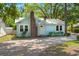 Cozy light blue home features a brick chimney, mature trees, and a metal roof at 309 Padgett Loop, Walterboro, SC 29488