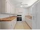 Traditional kitchen featuring white cabinets, butcher block countertops, and white appliances at 309 Padgett Loop, Walterboro, SC 29488