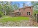 Spacious backyard showcasing a brick home, manicured lawn, and an outdoor pergola at 320 Compton Xing, Summerville, SC 29485