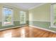 Bright bedroom with hardwood floors, green walls with white trim, and natural light from three windows at 320 Compton Xing, Summerville, SC 29485