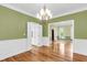 Open dining area with hardwood floors, a modern chandelier, and wainscoting with a view to other rooms at 320 Compton Xing, Summerville, SC 29485