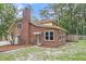 Brick home exterior featuring mature landscaping, an attached garage, and a rear entry door at 320 Compton Xing, Summerville, SC 29485