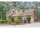Side view of the home showing the brick exterior, attached garage, and surrounding greenery at 320 Compton Xing, Summerville, SC 29485