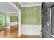 Inviting foyer featuring hardwood floors, green walls with white wainscoting, and a glimpse of the dining area at 320 Compton Xing, Summerville, SC 29485