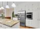 Open kitchen design with stainless steel appliances, white cabinets, and granite countertop island at 320 Compton Xing, Summerville, SC 29485