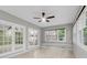 Bright sunroom with tiled floors, a ceiling fan, large windows, and French door access at 320 Compton Xing, Summerville, SC 29485