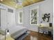 Bright bedroom with wood floors, ceiling fan, desk, and two large windows at 33 Pitt St # 3, Charleston, SC 29401