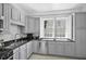 Well-lit kitchen featuring gray cabinets, black countertops, stainless steel appliances and a window view at 33 Pitt St # 3, Charleston, SC 29401