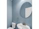 Cozy powder room features a blue wall, and a round mirror over a pedestal sink at 3310 Hartwell St, Johns Island, SC 29455
