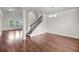 Spacious living room with hardwood floors, a decorative staircase, and elegant chandelier at 3310 Hartwell St, Johns Island, SC 29455