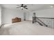 Spacious loft area with neutral carpet, ceiling fan, and stairs with dark-stained railing at 3310 Hartwell St, Johns Island, SC 29455