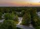 Scenic aerial view of a residential neighborhood with lush trees and a beautiful sunset backdrop at 334 Mossy Oak Way, Mount Pleasant, SC 29464