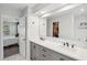 Bathroom featuring dual sinks, quartz countertop, soft lighting, and a glimpse into the walk-in closet at 334 Mossy Oak Way, Mount Pleasant, SC 29464