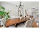 This dining room features a wooden table, six linen chairs, and a modern chandelier, bathed in natural light at 334 Mossy Oak Way, Mount Pleasant, SC 29464