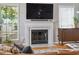 Close-up of a living room fireplace with white mantle, a TV, and a cabinet at 334 Mossy Oak Way, Mount Pleasant, SC 29464