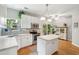Bright kitchen boasts white cabinetry, stainless steel appliances, an island, and hardwood floors at 334 Mossy Oak Way, Mount Pleasant, SC 29464