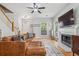 Open-concept living room featuring a fireplace, hardwood floors, and a comfortable leather couch at 334 Mossy Oak Way, Mount Pleasant, SC 29464