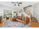 Open-concept living room featuring a leather couch, a fireplace, hardwood floors, and access to dining at 334 Mossy Oak Way, Mount Pleasant, SC 29464
