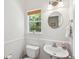 Classic powder room features a pedestal sink, round mirror, natural light, and decorative window shade at 334 Mossy Oak Way, Mount Pleasant, SC 29464