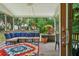 Cozy screened porch features a seating area, colorful rug, and lush greenery, perfect for relaxing outdoors at 334 Mossy Oak Way, Mount Pleasant, SC 29464