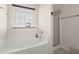 Bright bathroom showcasing a soaking tub, glass-enclosed shower, and window with blinds at 3364 Middlesboro Ave, Summerville, SC 29485