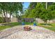 Cozy fire pit area is surrounded by smooth stones, plants and a wood fence, perfect for outdoor relaxation at 3364 Middlesboro Ave, Summerville, SC 29485