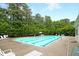 Community swimming pool with lounge chairs, surrounded by lush landscaping and shady trees at 3364 Middlesboro Ave, Summerville, SC 29485