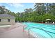 Large in-ground community swimming pool and jacuzzi area with trees, lounge chairs, and umbrella table at 3364 Middlesboro Ave, Summerville, SC 29485