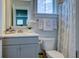 Bright bathroom featuring a gray vanity, white floral arrangement, and a stylish ruffled shower curtain at 3539 Habenaria Rd # 28, Mount Pleasant, SC 29466