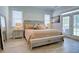 Bright bedroom features wood-look floors, large bed, bench and french doors to back yard at 3539 Habenaria Rd # 28, Mount Pleasant, SC 29466