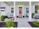 Inviting front porch with comfortable seating, potted plants, and a vibrant pink door, creating a warm welcome at 3539 Habenaria Rd # 28, Mount Pleasant, SC 29466