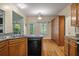 This kitchen features custom wooden cabinets, a black dishwasher, and a sink overlooking the back porch at 3872 James Bay Road Rd, Johns Island, SC 29455