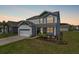 Charming two-story home featuring a manicured lawn and attached two-car garage at 411 Bering Ln, Summerville, SC 29486