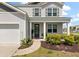 Inviting two-story home featuring a cozy front porch and well-maintained landscaping at 411 Bering Ln, Summerville, SC 29486