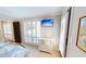 Modern bedroom with large windows, white shutter blinds, and a flat screen TV at 4209 Ocean Club Dr, Isle of Palms, SC 29451